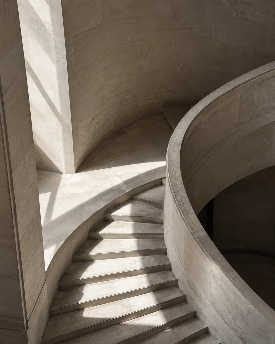 An abstract architectural study of light and shadow on a curved stone staircase